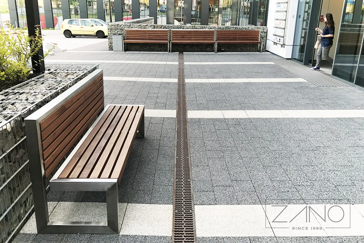 En modern stadsbänk i rostfritt stål och trä